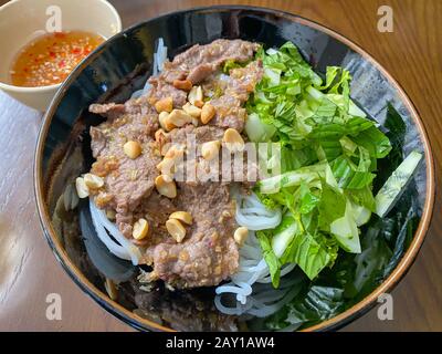 Vietnamesische geschmorte Reis-Nudel aus Rindfleisch, serviert mit Gemüse und Erdnüssen Stockfoto