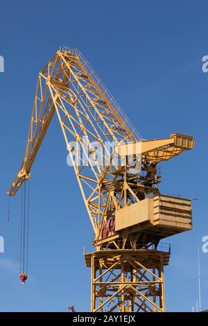 Riesiger gelber Metallkran, der täglich auf den Werften des Hafen von Cádiz, Andalucía, Spanien, in der Nähe der Astilleros-Allee arbeitet Stockfoto