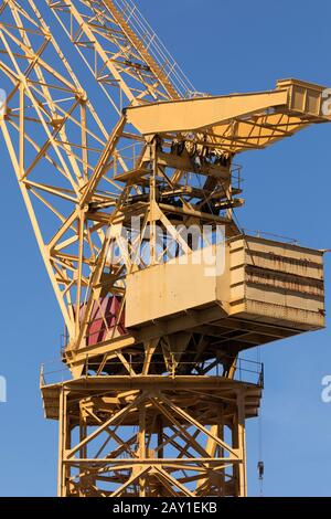 Riesiger gelber Metallkran, der täglich auf den Werften des Hafen von Cádiz, Andalucía, Spanien, in der Nähe der Astilleros-Allee arbeitet Stockfoto