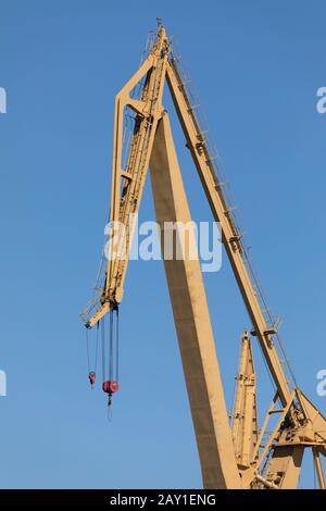 Riesiger gelber Metallkran, der täglich auf den Werften des Hafen von Cádiz, Andalucía, Spanien, in der Nähe der Astilleros-Allee arbeitet Stockfoto