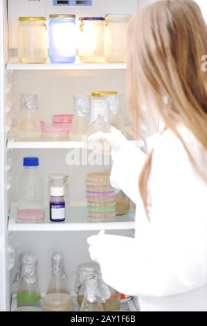 Junger Wissenschaftler öffnet Kühlschrank im Labor Stockfoto