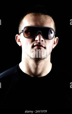 Modische Mode Jungmannporträt auf schwarzem Hintergrund Stockfoto