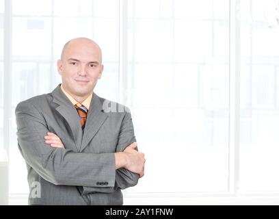 Attraktiver seriöser Geschäftsmann mit gefalteten Armen Stockfoto