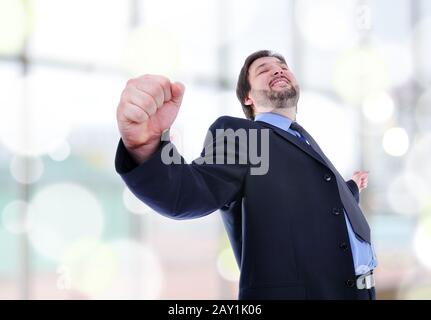 Business man steht mit Fäusten am Sieg fest. Stockfoto