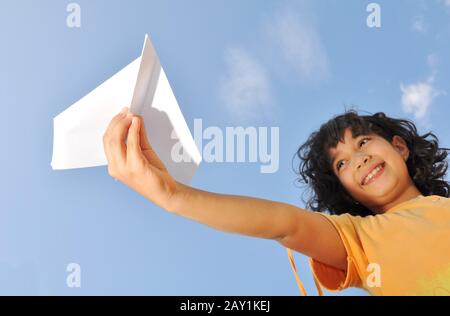 Kleines süßes Mädchen, das ein Flugzeug hält Stockfoto