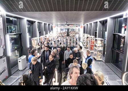 Menschen, die während der Coronovirus-Pandemie auf einer internationalen Messe für Rolltreppen Schlange stehen, einige von ihnen tragen Maske, um sie zu schützen Stockfoto