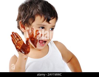 Süßes, unordentliches Kind, isoliert auf weißer Schokolade Stockfoto