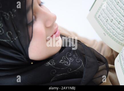 Kleines Mädchen las heiligen Koran und lächelt Stockfoto