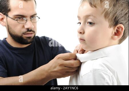 Portrait eines kleinen Jungen, der von seinem Vater mit Hemd unterstützt wurde Stockfoto