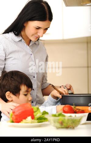 Mutter und Kinder bereiten eine Mahlzeit zu Stockfoto