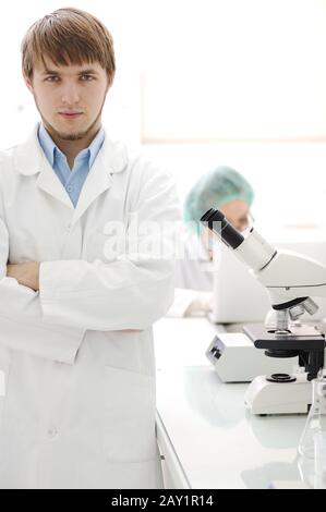 Zwei Wissenschaftler, die mit Mikroskop im Labor arbeiten Stockfoto