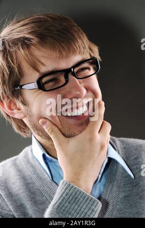 Junger kaukasischer Mann mit Brille lachend Stockfoto