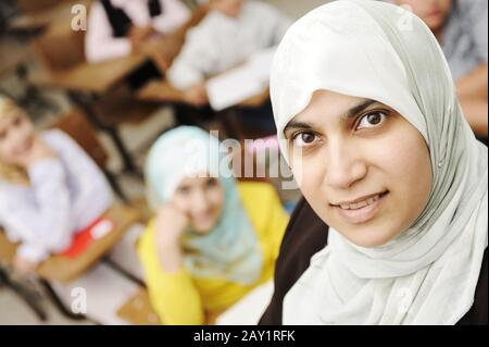 Muslimische Lehrerin im Klassenzimmer mit Kindern Schüler (Studenten) Stockfoto