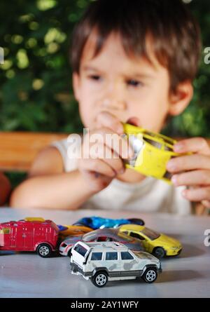 Kinder, die im Sommer mit Autos spielen, spielen im Freien Stockfoto