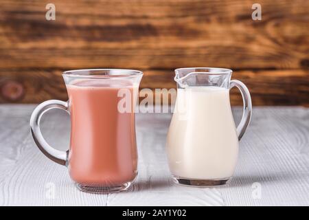 Schokolade, Milch und Soja Milch in Glas am weißen Tisch über dunklen Hintergrund Stockfoto