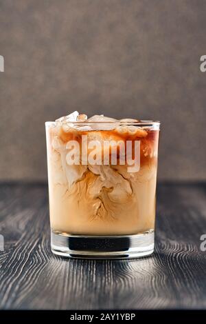 Eiskaffee mit Sahne auf dunklem Hintergrund Stockfoto