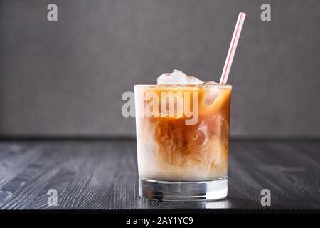 Eiskaffee mit Sahne auf dunklen Holztisch Stockfoto