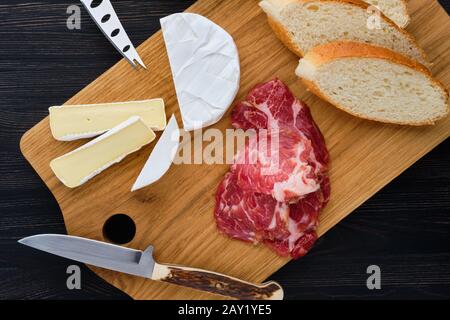 Ansicht von oben der Camembert Sandwich mit geräuchertem Speck auf dunklen Holztisch. Stockfoto