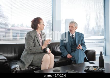 Zwei Kollegen, die während eines Geschäftstreffen mit Zigarette eine Pause einlegen Stockfoto