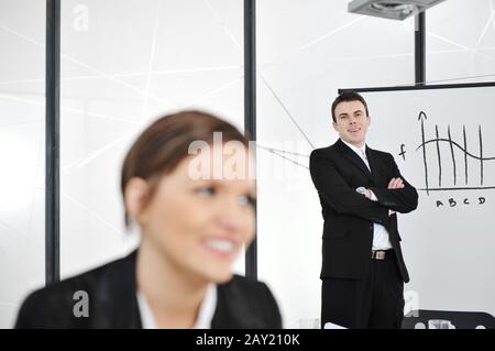 Fröhlicher junger Geschäftsmann in der Geschäftspräsentation im Büro Stockfoto