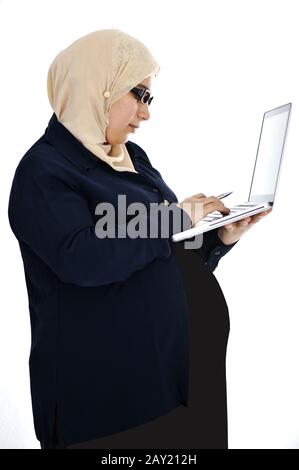 Schwangere muslimische Araberin mit Laptop Stockfoto