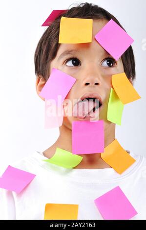 Kleiner Junge mit Memo-Notizen im Gesicht Stockfoto