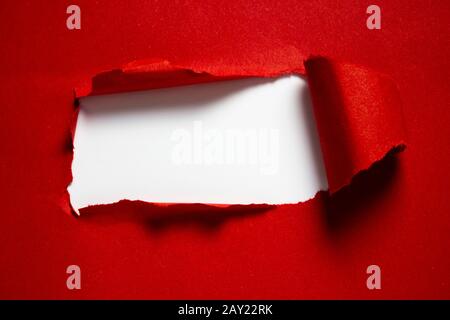 Copyspace reißt rotes Papier mit weißem Hintergrund in der Mitte und harten Schatten zum Einfügen von Text Stockfoto