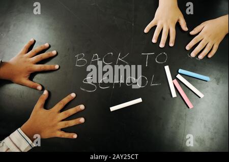 Mehrkämpfe Kinder greifen mit Kelch auf Tafel: Zurück zur Schule! Stockfoto