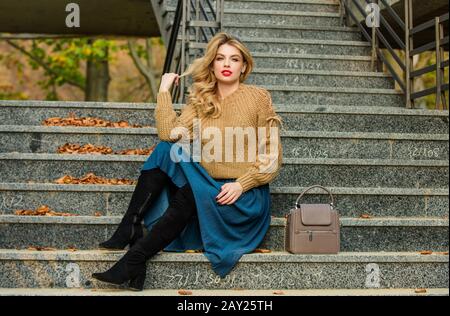 Netter Tag. Mädchen in Wellrock und Pullover. Plissierter Trend. Herbstfrau lockiges Haar im Freien. Legere Style-Studentin. Herbstsaison. Mädchen lange blonde Haartreppen. Weibliche Schönheit. Modemodell. Stockfoto