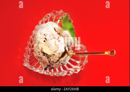 Schokoladeneis in Schüssel über rotem Hintergrund Stockfoto