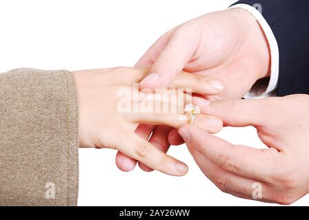 Junger weißer Mann, der einen Ring auf den Finger der Frau legt Stockfoto