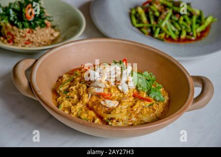 Thai-Food zeichnet sich durch leicht zubereitete Gerichte mit starken aromatischen Komponenten und einem würzigen Rand aus. Hier ist ein Krabbencurry, lange Bohnen und Schweinefleisch. Stockfoto