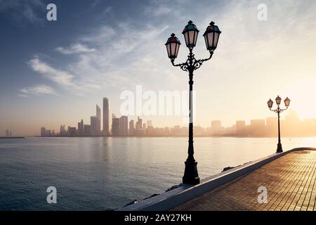 Urbane Skyline mit Wolkenkratzern bei schönem Sonnenaufgang. Stadtbild Abu Dhabi, Vereinigte Arabische Emirate. Stockfoto