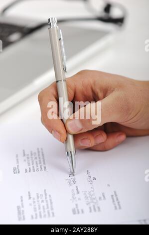 Die Hand der Geschäftsfrau, die eine Unterschrift auf das Dokument legt Stockfoto
