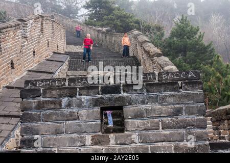 Ein Fragment der Chinesischen Mauer in Mutianyu, das von russischen Touristen vandalisiert wurde (das Schild ist auf Russisch) Stockfoto