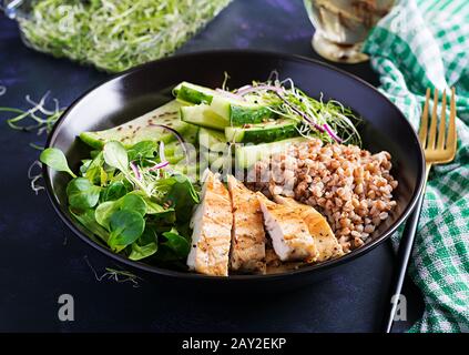 Mittagssalat. Buddhaschüssel mit Buchweizenporridge, gegrilltem Hühnerfilet, Maissalat, Mikrogrüns und Daikon. Gesunde Ernährung. Stockfoto