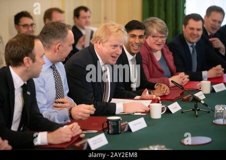 Premierminister Boris Johnson neben Gesundheitsminister Matt Hancock (links), Kabinettssekretär Mark Sedwill (zweite Linke), Schatzkanzlerin Rishi Sunak (vierte Rechte), Arbeits- und Rentensekretärin Therese Coffey (dritte Rechte), Wohnungsbauminister Robert Jenrick (zweite rechte), Und Verkehrsminister Grant Shapps (rechts) während der ersten Kabinettssitzung in der 10 Downing Street, London, seit der Umbildung. Stockfoto