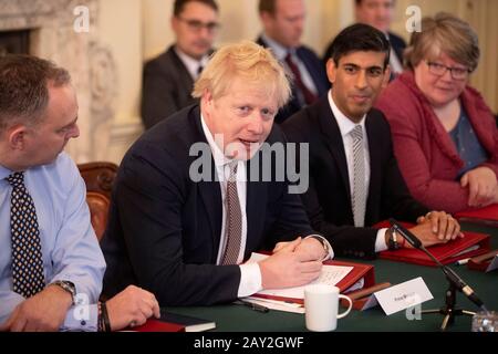 Premierminister Boris Johnson neben dem neuen Schatzkanzler Rishi Sunak (zweite rechts), Kabinettsekretär Mark Sedwill (links) und Arbeits- und Rentensekretärin Therese Coffey (rechts) während der ersten Kabinettssitzung in der 10 Downing Street, London, seit der Umschüffung. Stockfoto