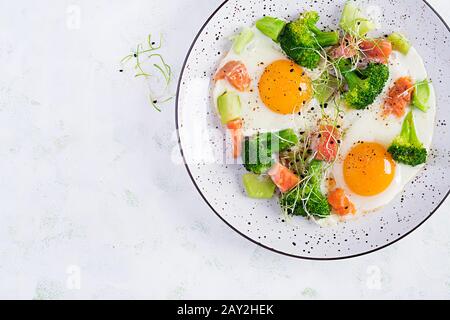 Ketogene/paläogene Ernährung. Spiegeleier, Lachs, Brokkoli und Mikrogrün. Keto Frühstück. Brunch. Draufsicht, Overhead Stockfoto