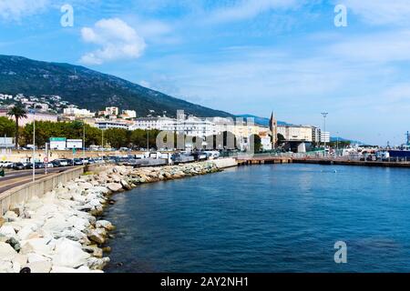 Bastia, FRANKREICH - 16. SEPTEMBER 2018: Blick auf Bastia, auf Korsika, Frankreich, seit dem Meer, mit Handelshafen und Notre-Dame de Lourdes churc Stockfoto