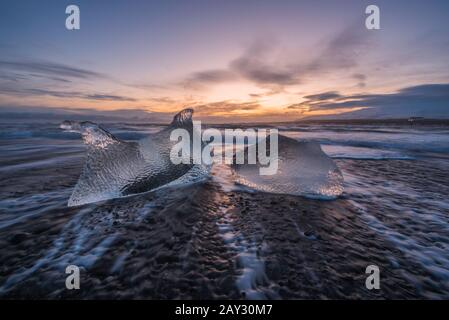 Gebrochenes Eis aus angespülten Eisberge am Jökulsárlón schwarzen Strand Sonnenuntergang Jökulsárlón Süd-Ost-Island Stockfoto