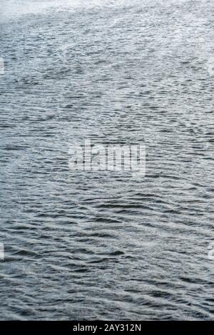 Etwas turbulentes Wasser wellt auf River Fowey, Lostwithiel, Corrnwall. Metapherapheres, luftiges Wetter, Rippeleffekt, Wasserspiegelungen, wässriger Hintergrund. Stockfoto