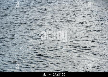 Etwas turbulentes Wasser wellt auf River Fowey, Lostwithiel, Corrnwall. Metapherapheres, luftiges Wetter, Rippeleffekt, Wasserspiegelungen, wässriger Hintergrund. Stockfoto