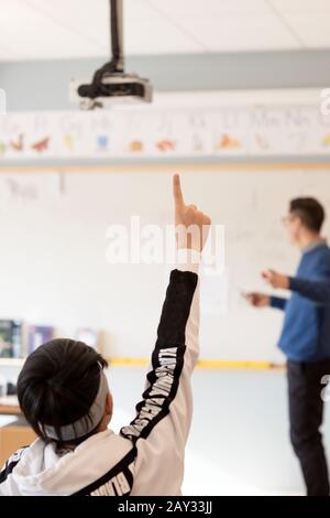 Teenager, die Erhöhung der Hand im Klassenzimmer Stockfoto