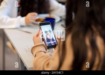 Mädchen, die sich ein Foto auf ihrem Telefon ansieht Stockfoto