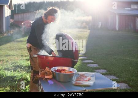 Frau mit Grill im Garten Stockfoto