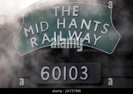 Ein Schild der Mid Hants Railway an der Vorderseite des Flying Scotsman, nachdem es im Bahnhof Alton in Hampshire angekommen ist, um die Watercress Line der Mid Hants Railway offiziell wieder zu eröffnen. Stockfoto