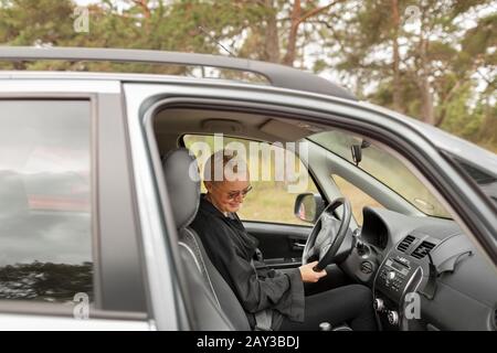 Lächelnde Frau sitzen im Auto Stockfoto