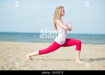 Junge Dame Yoga zu praktizieren. Training in der Nähe von Meeresküste des Ozeans. Stockfoto