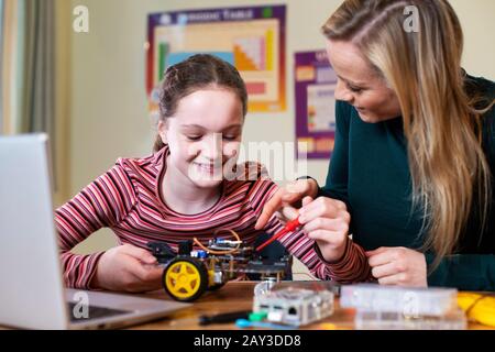 Weibliche Lehrerin Helfing Girl Building Robotic Car In Science Lektion Stockfoto